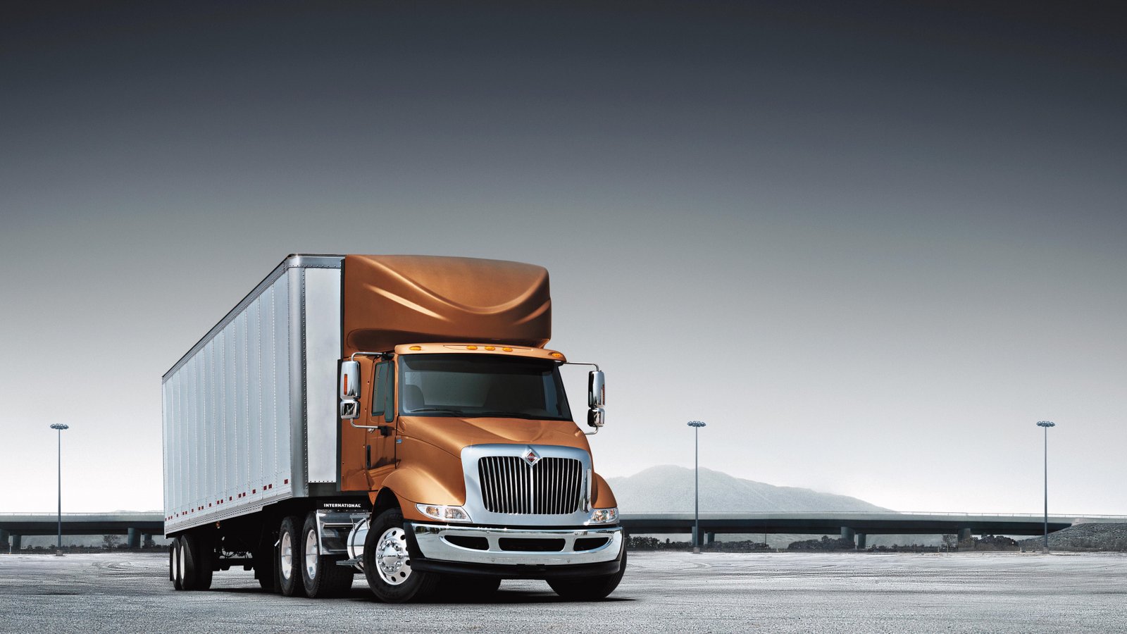 "Photograph of a red semi-truck on a highway under a clear sky, overlaid with digital icons representing safety, compliance, and temperature control for logistics."